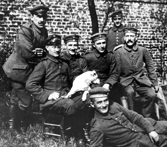 Hitler (all'estrema destra, seduto) con i suoi commilitoni del Reggimento di Fanteria di Riserva Bavarese 16 (1914-18 circa) Foto: Bundesarchiv, Bild 146-1974-082-44 / CC-BY-SA 3.0