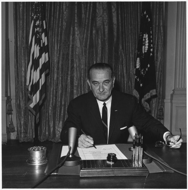 El Presidente Lyndon B. Johnson firma la resolución 