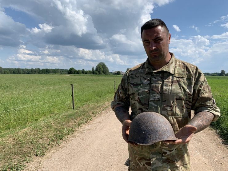 Gary Kostka holding a Soviet Helmet on the former battlefield. Found by a local farmer on his land. (Jonny Bay 2019)