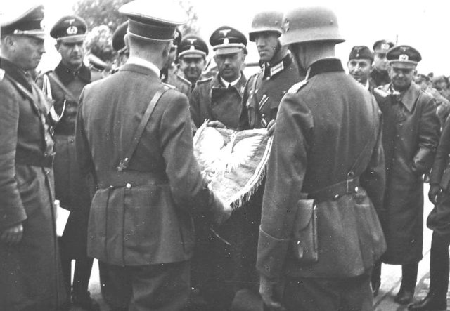 Himmler (behind flag) with Hitler (front left, back turned, holding flag) and Konrad Henlein (on the right) (Gauleiter Sudetenland) in Poland in September 1939.