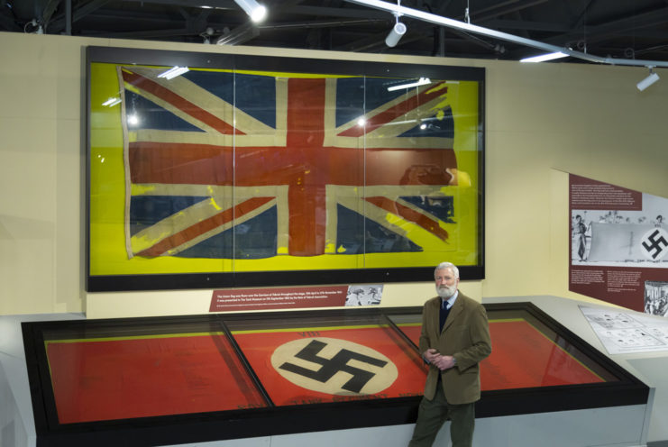 David Willey, curator of The Tank Museum with two flags associated with the siege of Tobruk in WW2. They form part of the new World War II exhibition.