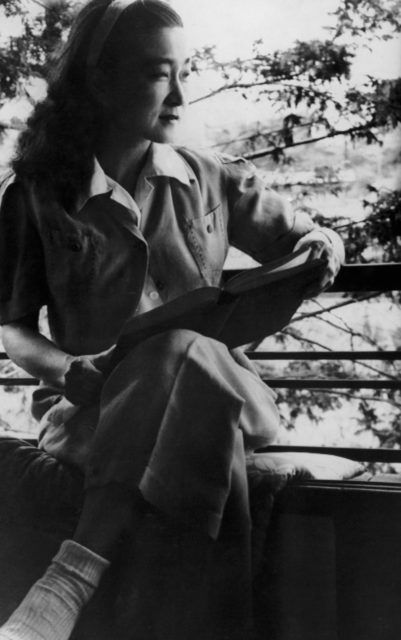 Iva Toguri D'Aquino sitting with a book