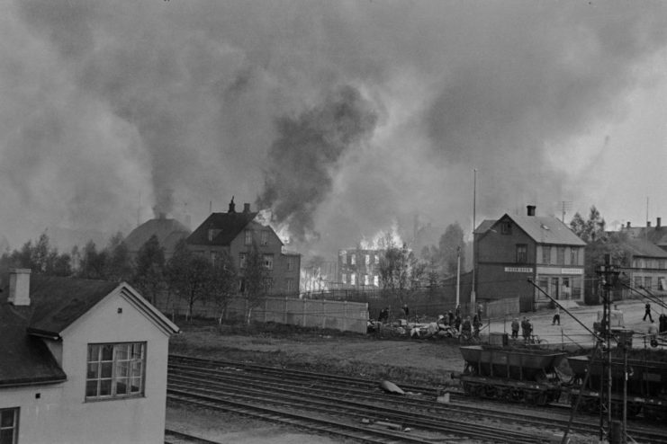 Smoke rising into the air behind buildings