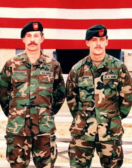 Gary Gordon and Randall Shughart standing in front of the American flag