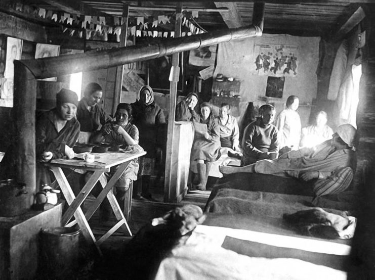 Female prisoners sitting in cramped barracks