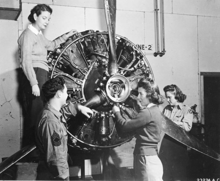 Three WASPs standing around a B-17 propellor with their instructor