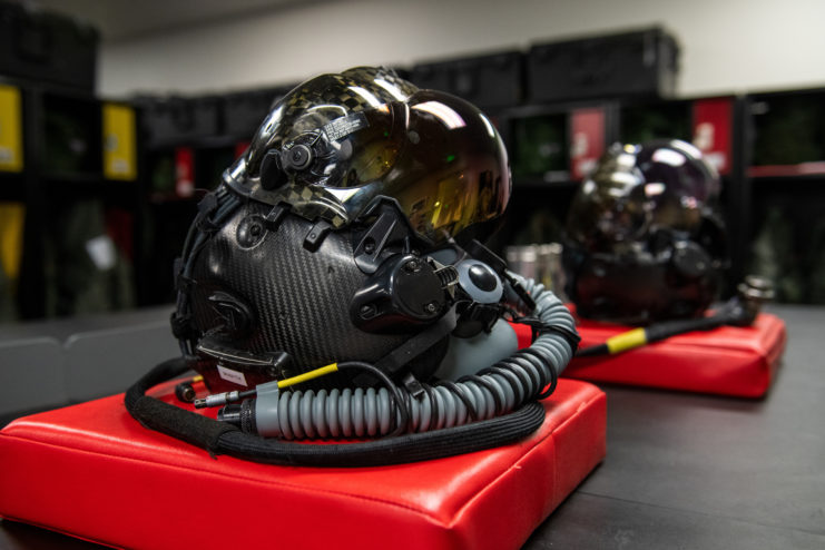 Two F-35 helmets on red mats