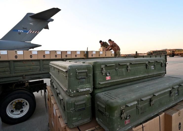 Two Ukrainian soldiers loading boxes onto a flatbed