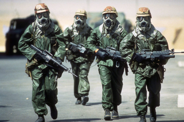 Four soldiers with the US 82nd Airborne Division dressed in chemical warfare suits