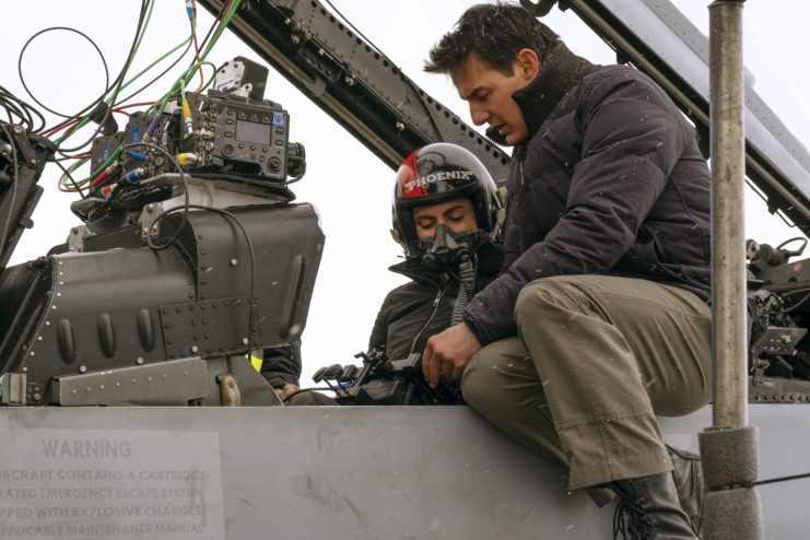 Tom Cruise speaking with Monica Barbaro