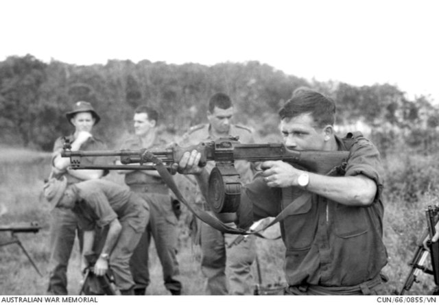 Australian soldier firing an RPD machine gun while others watch