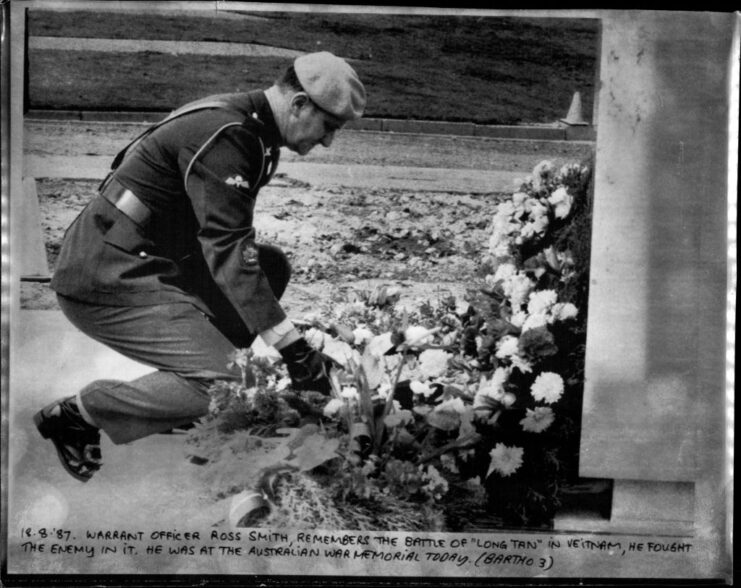 Warrant Officer Ross Smith kneeling before the Australian War Memorial