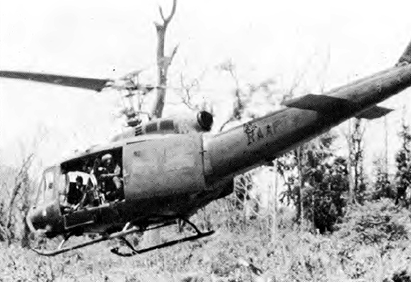 Bell UH-1D Iroquois hovering over a grassy area