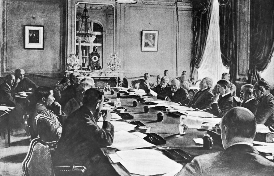 Diplomats sitting at a table in a large room