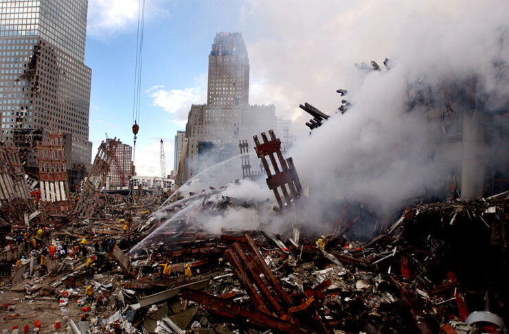 Rubble and steel piled on the ground, shrouded in smoke