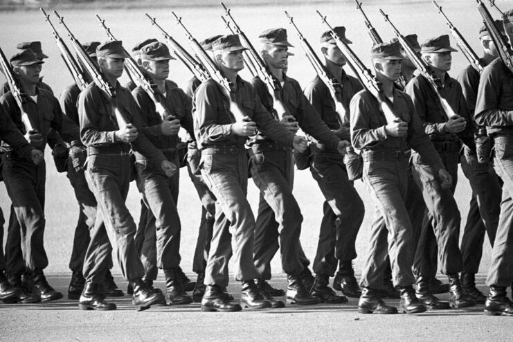 US Marine Corps recruits marching together with rifles against their shoulders