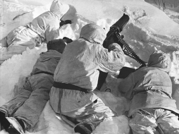 Four Finnish machine gunners lying in the snow while aiming their weapon