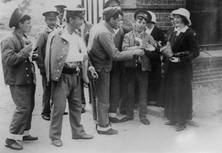 Women standing with wounded soldiers outside of a building