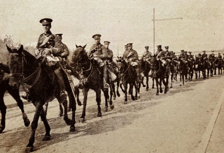 Members of the British Expeditionary Force (BEF) riding on horseback down a road