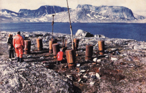 Members of the Canadian Coast Guard standing with the remnants of Weather Station Kurt