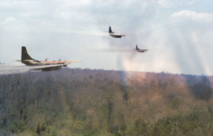 Three Fairchild UC-123B Providers spraying herbicide over a forest