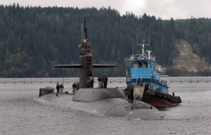 Tugboat sailing past the USS Parche (SSN-683) while she's surfaced