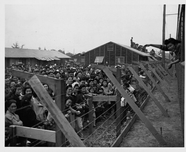 Japanese Americans standing at the fence surrounding the Santa Anita Assembly Center