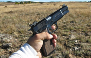 Browning Hi-Power being held up in a field