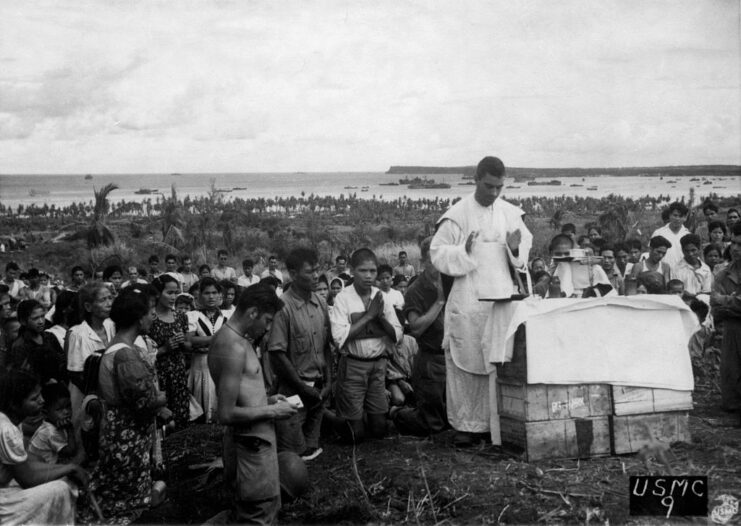 Chamorros gathered around a chaplain who's standing at a makeshift altar