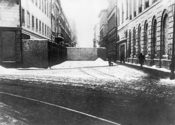 Concrete wall running across a street, erected between two buildings