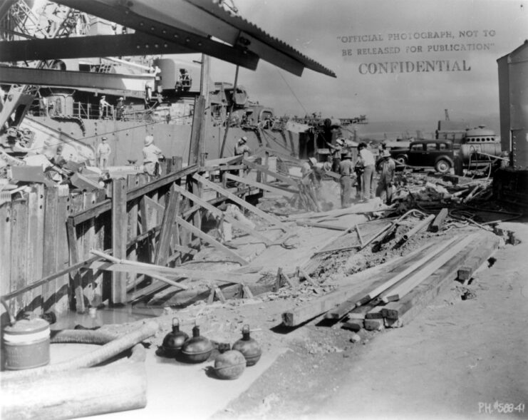 Workers standing among piles of rubble