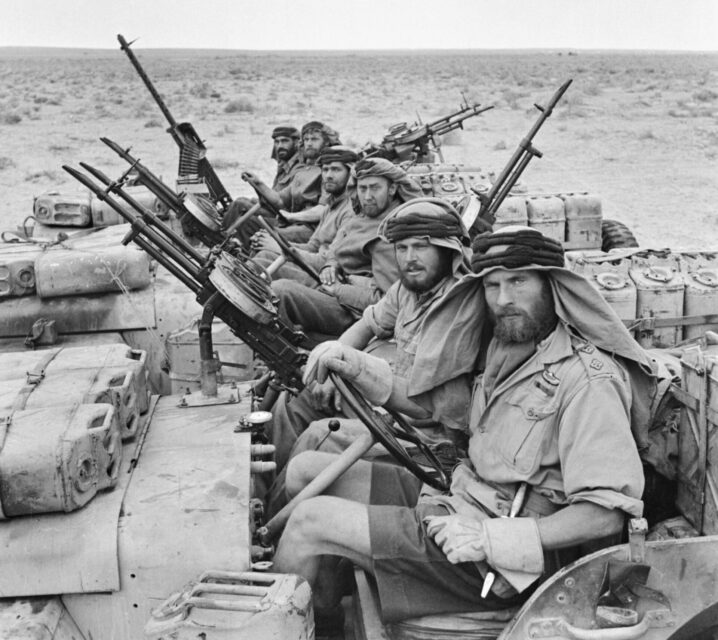 Six members of the Special Air Service (SAS) sitting in three vehicles in the desert