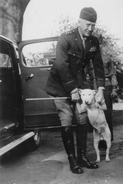 George Patton standing with his dog at the passenger side door of a vehicle