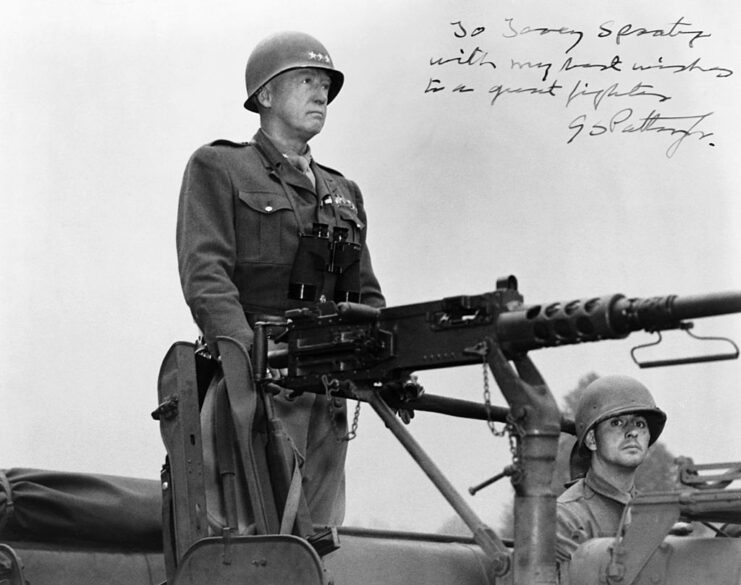 George Patton standing at the buttstock of a large gun