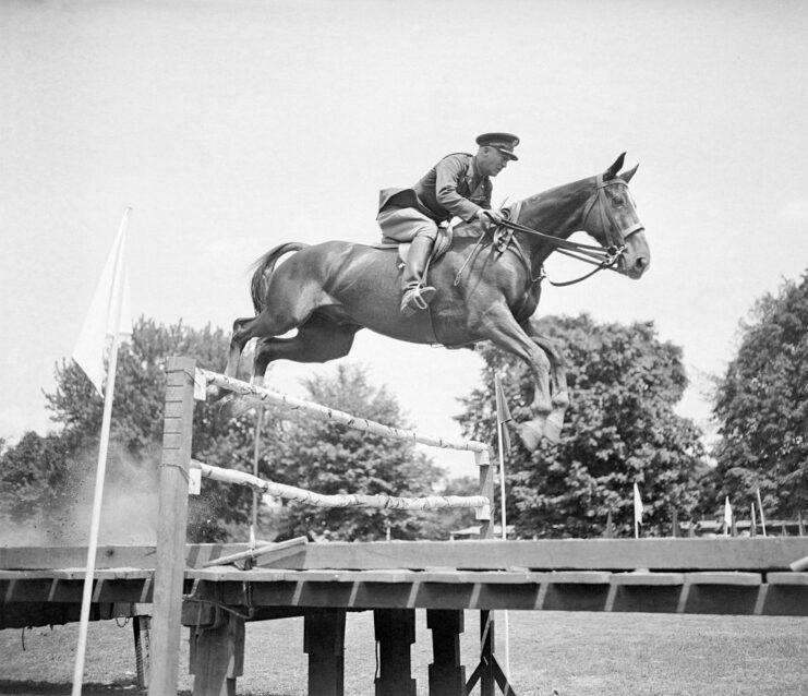 George Patton jumping over a course obstacle on horseback 