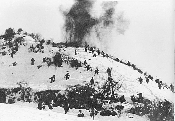 Chinese troops running up a snow-covered hill