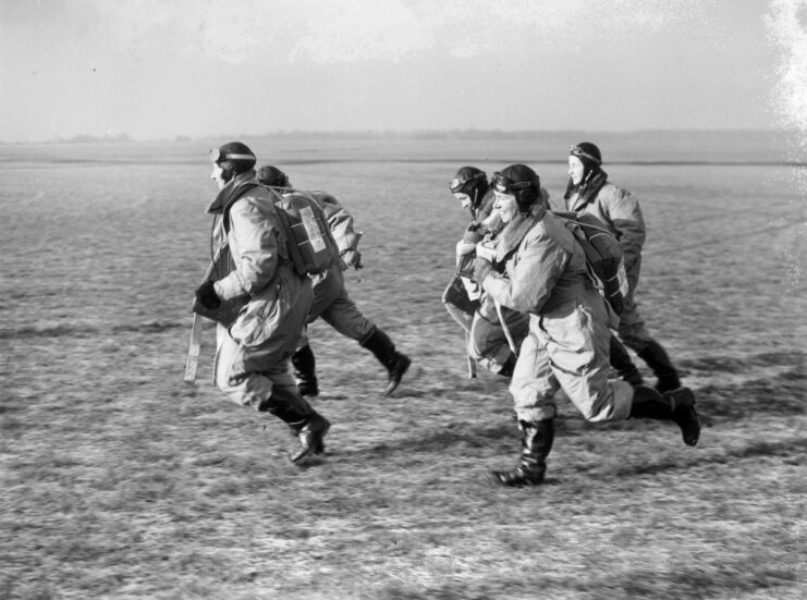 Five female pilots running across a field