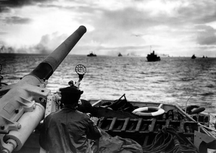 Gunner standing next to the naval gun aboard a destroyer