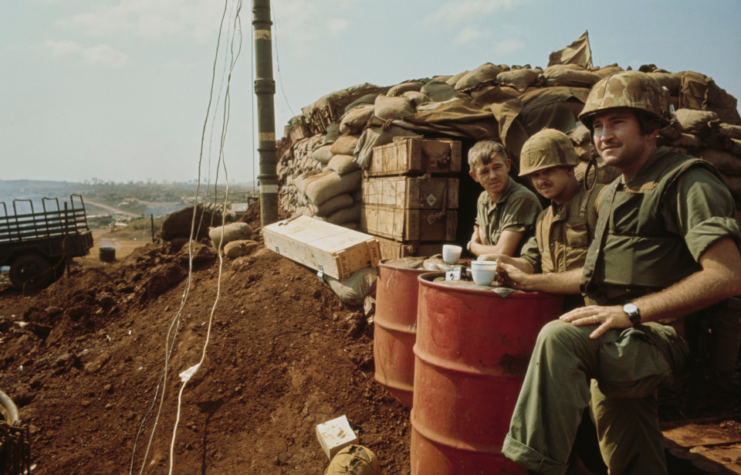 Officers of the United States Marines Corps drinking coffee, repurposing oil barrels as tables, during a lull in shelling at Khe Sanh Combat Base, a US Marines outpost south of the Vietnamese Demilitarized Zone (DMZ), in Khe Sanh, South Vietnam, 1st March 1968.