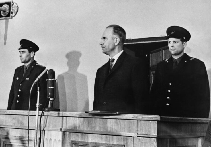 Oleg Penkovsky standing in court, with two police officers standing behind him