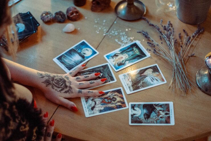 Hand placed atop tarot cards laid out on a table