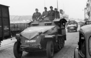 German soldiers manning a Sd.Kfz. 251 in the middle of the street