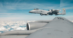 An A-10 Thunderbolt II in the air with the wing of a KC-135 in the foreground