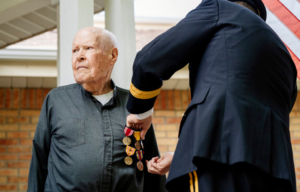 Father Ed Flaherty, S.J., receives medals for his wartime service.