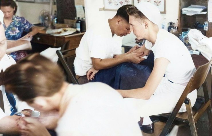 Two sailors being administered vaccines