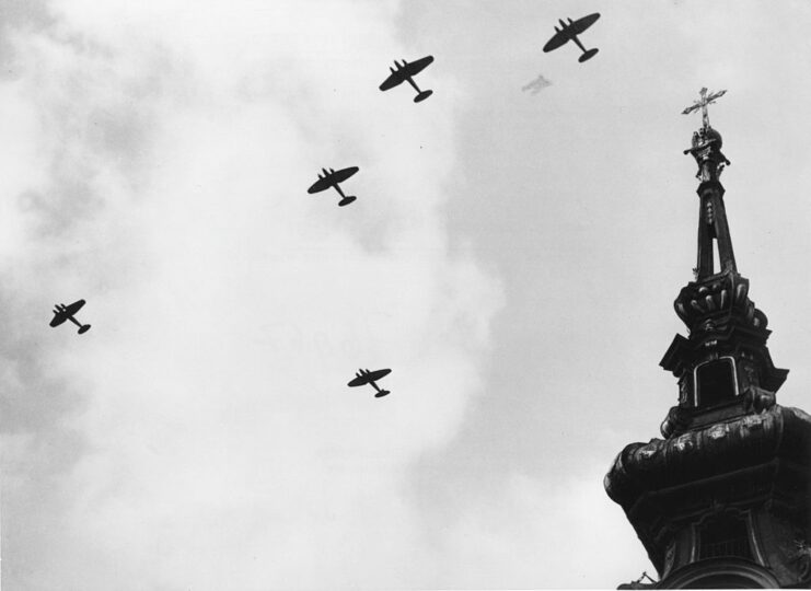 Five aircraft flying over a church