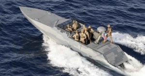 Eight members of the Special Warfare Combatant-Crew in a motorboat at sea