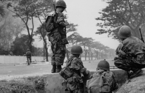 Soldiers standing along the side of a road