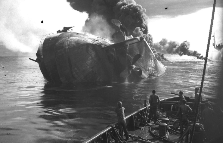 Sailors watching the USS Mississinewa (AO-59) sinking beneath the ocean's surface