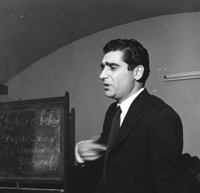 Robert Capa standing next to a chalkboard